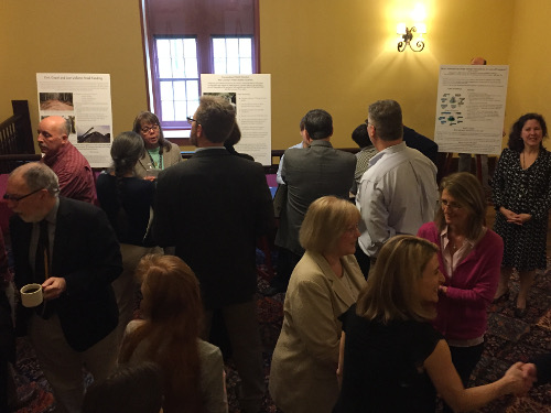 A group listening to a poster presentation at the Partnership Breakfast