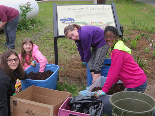 A group of students plant a rain garden