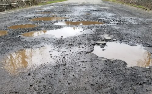 Puddles and potholes on a gravel road
