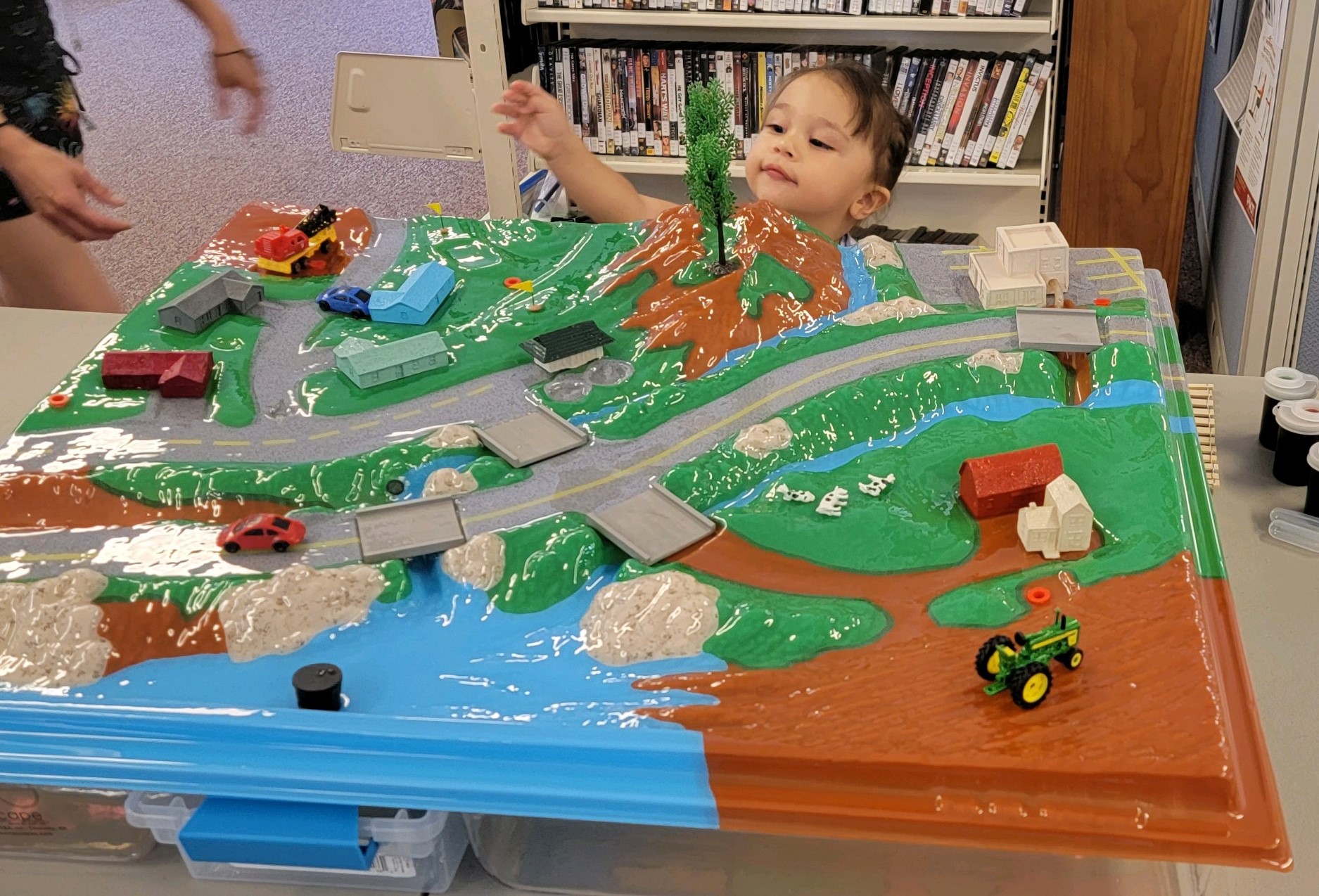 A child reaches for the Enviroscape watershed model