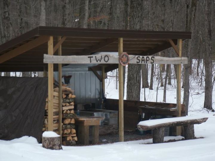 A pavilion with stacked firewood in the snow