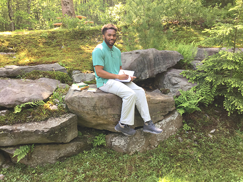 Anton Adams summer intern Pike County Conservation District sitting on a rock wall