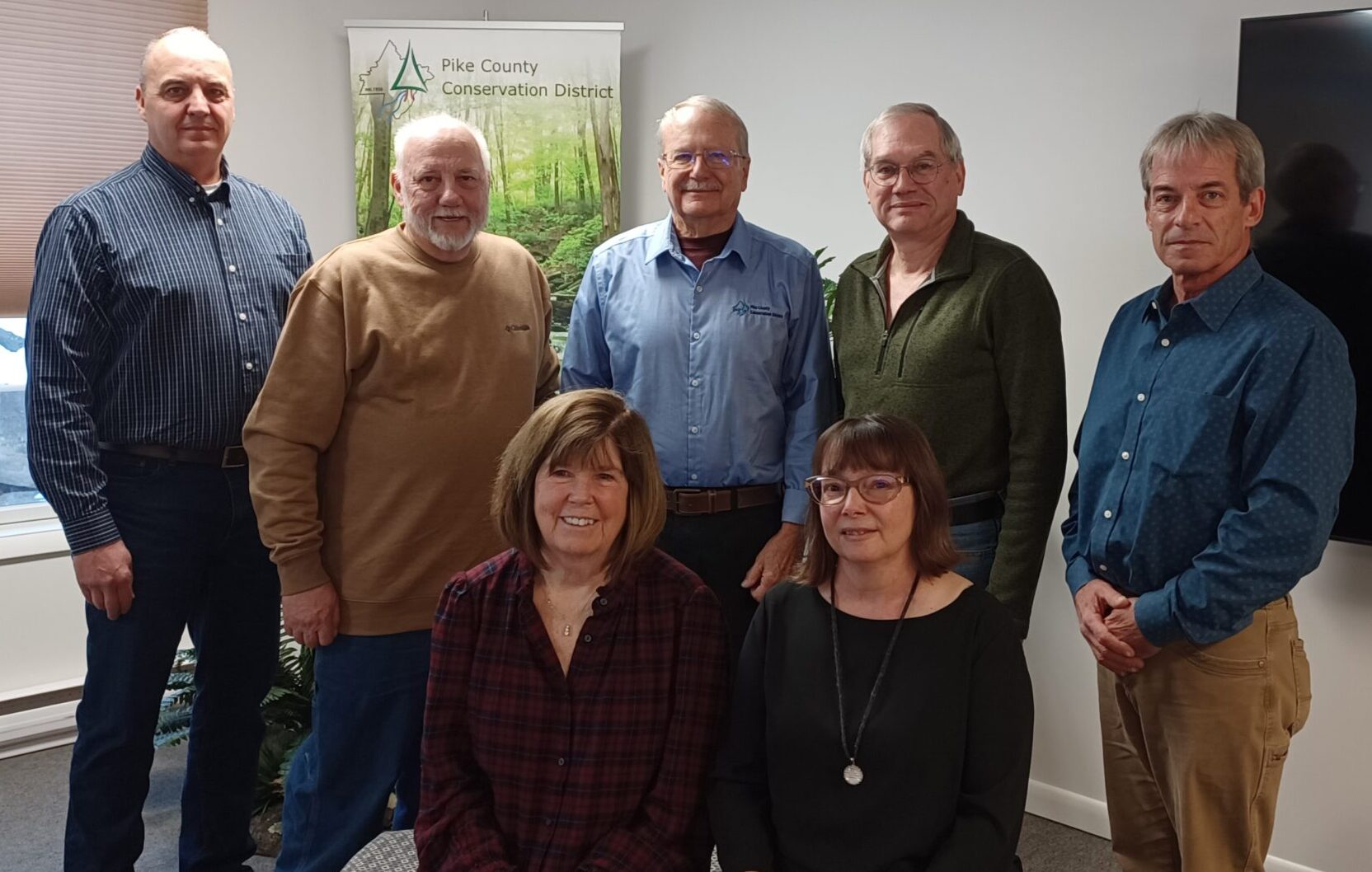 Board members pose for a group photo in the District education room