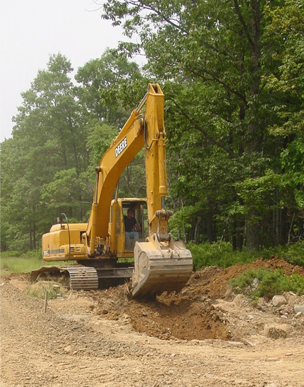A large construction vehicle digs up soil