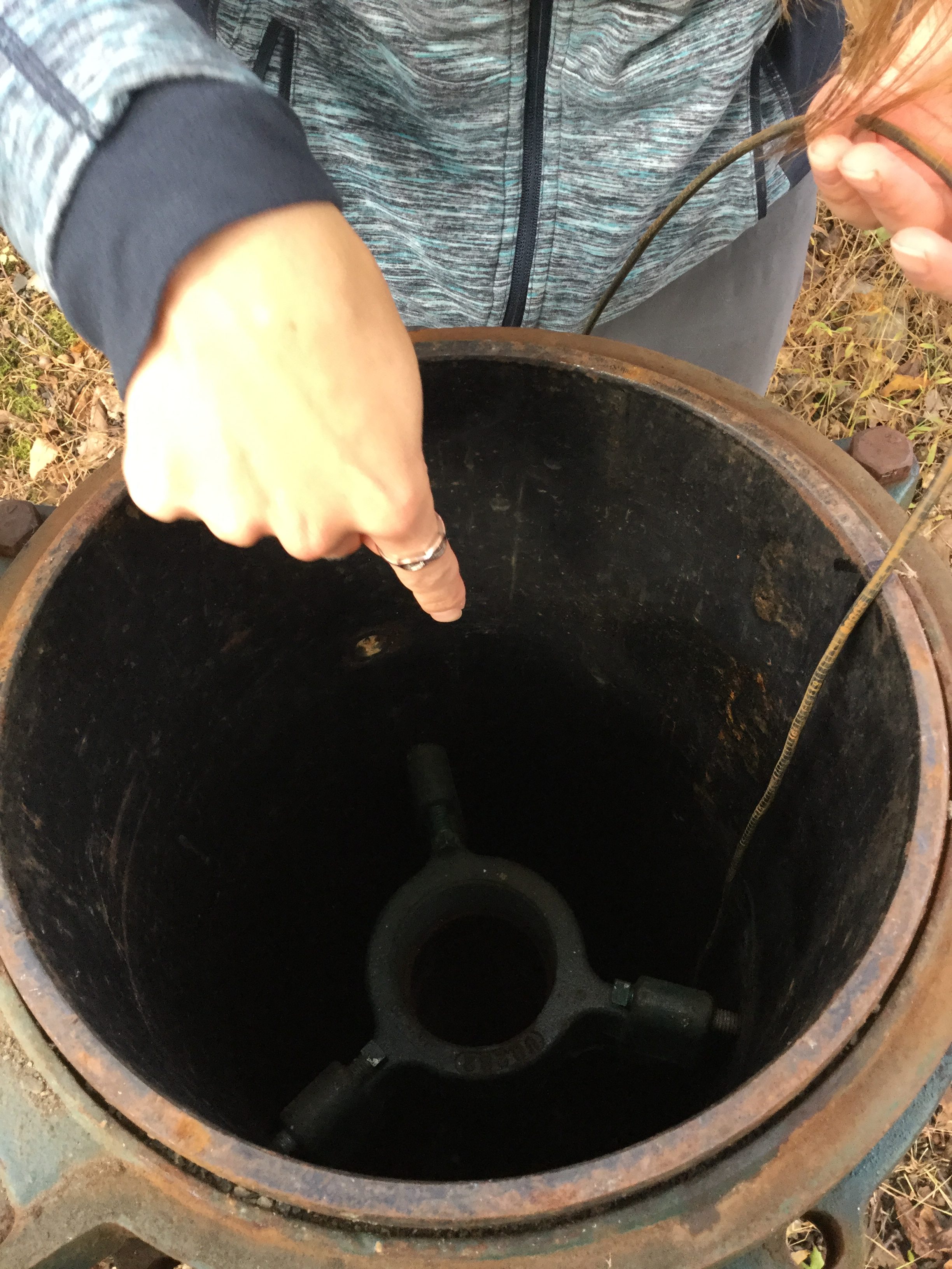 rachel pointing into a well, with the probe down inside of it.