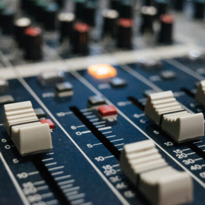 A close up of sliders on an audio editing board