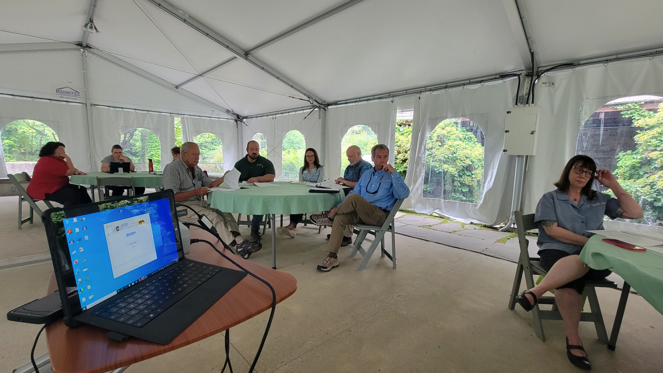 Board meeting outside under a large tent