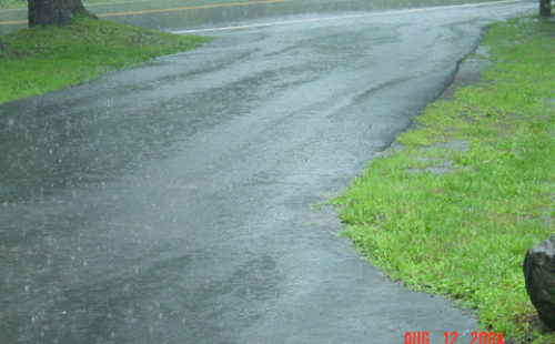 Rainwater runoff on a Pike County, PA impervious surface driveway. Proactive measures can help manage stormwater.