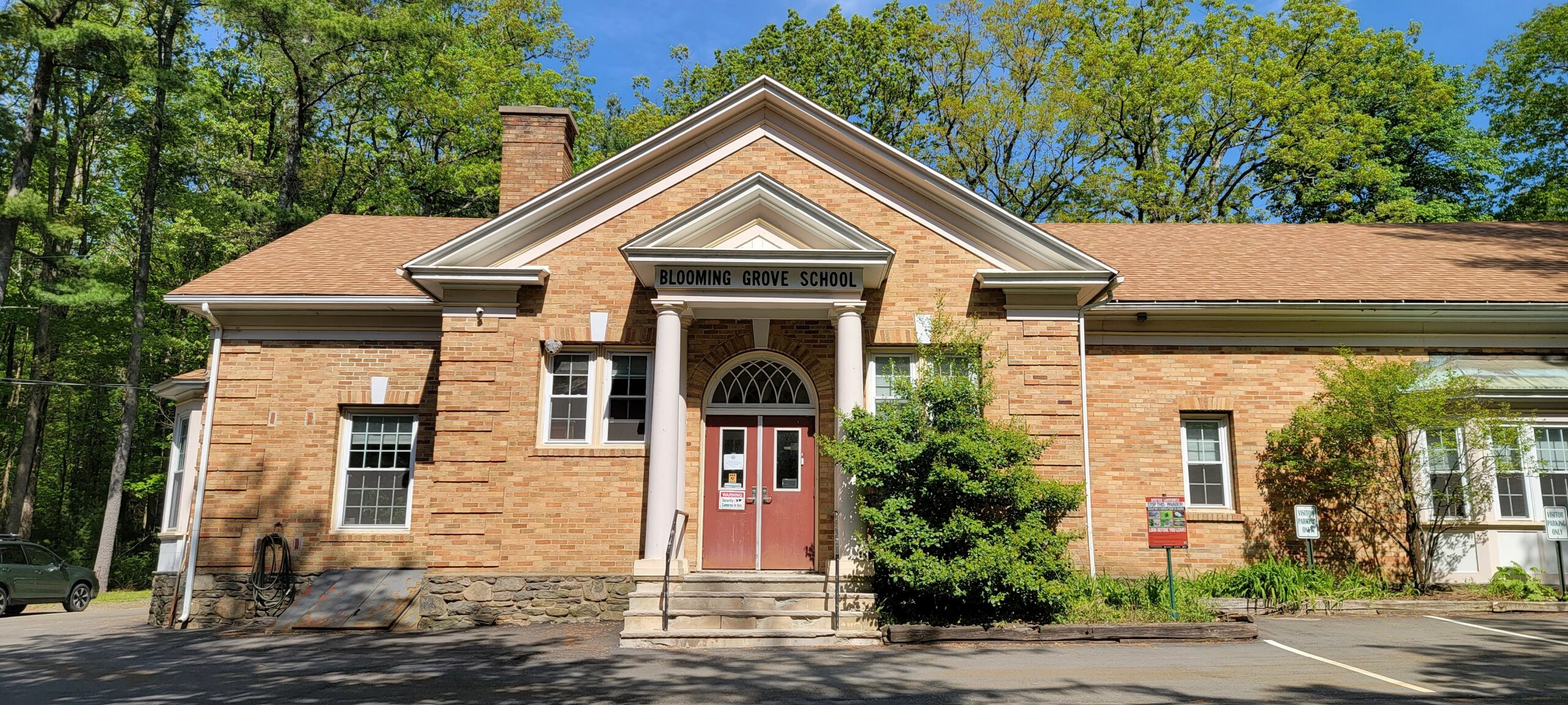 District building in the summer with two green trees in front