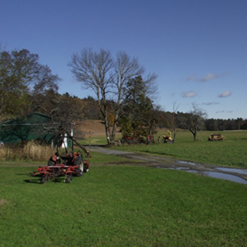 Agriculture equipment in a field surrounded by forest