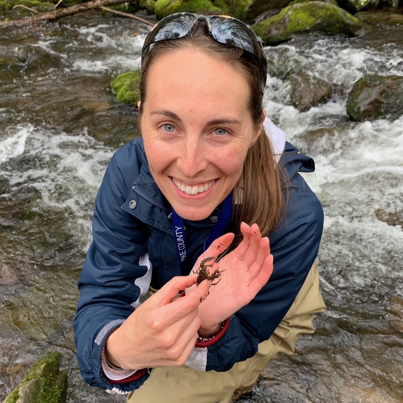 Watershed specialist holds a dragonfly nymph up for the camera.