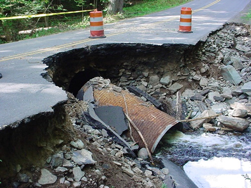 A pipe collapsing under a paved road