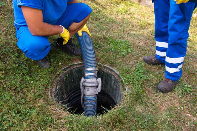 A man pumping out a septic tank